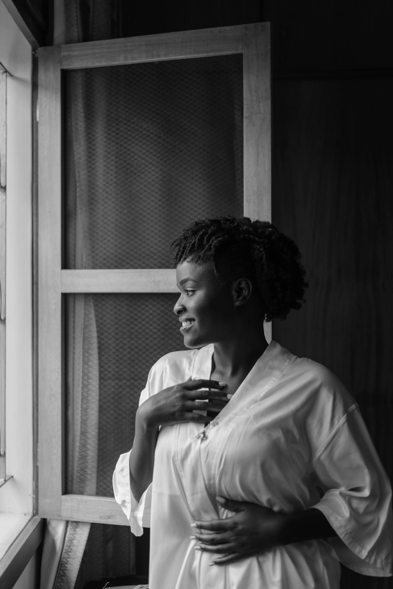 A woman in profile by a window, thoughtful.
